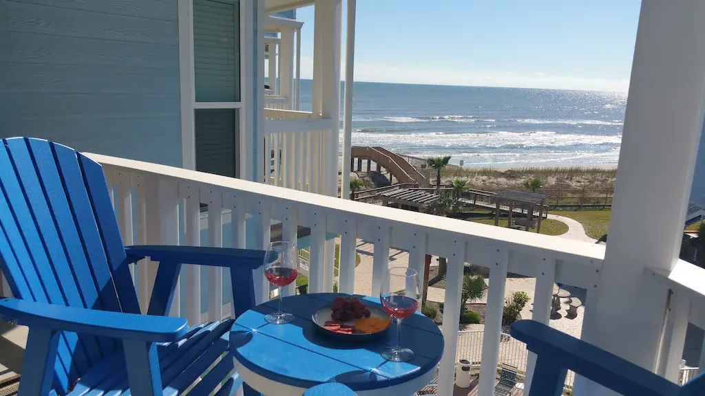 Balcony at Seascape Condo 2308 with blue Adirondack chairs, wine and gulf views
