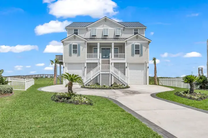Front exterior with double staircase, palm landscaping, and two-car garage at Fishwife