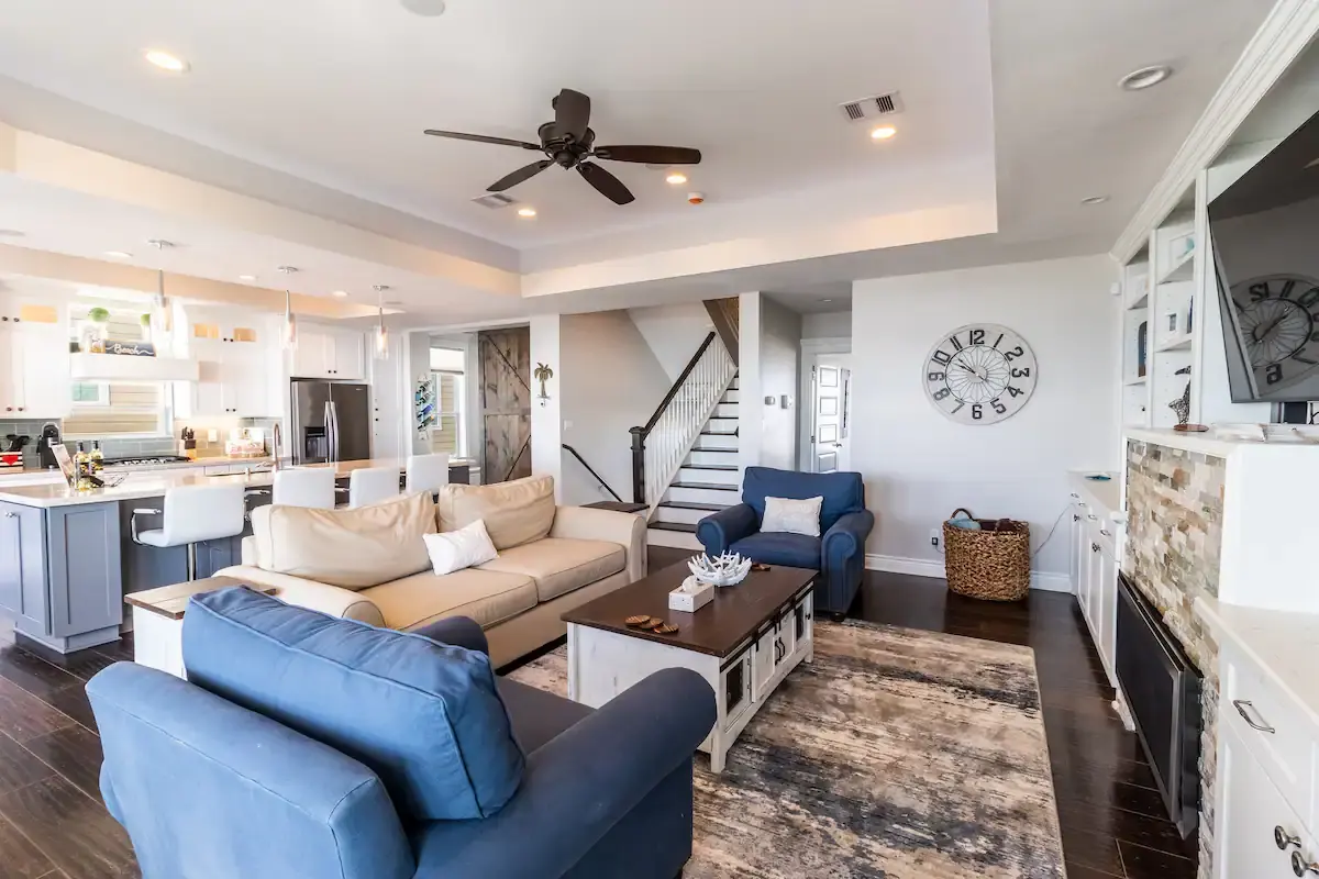 Open-concept lounge with staircase and island kitchen at Sunrise on the Beach