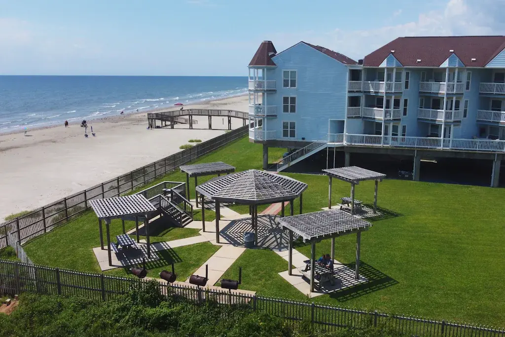Beachfront pergolas and lawn beside the sand at the Seascape complex near Condo 2308