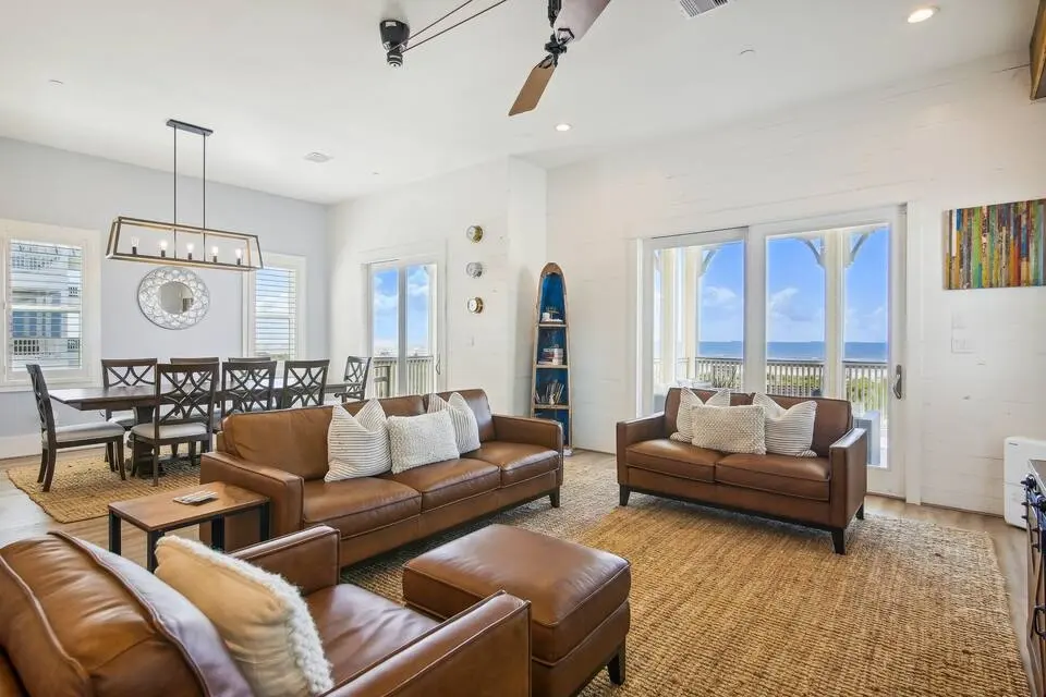 Living room with leather sofas, dining area, and beach views at Dorado Grande