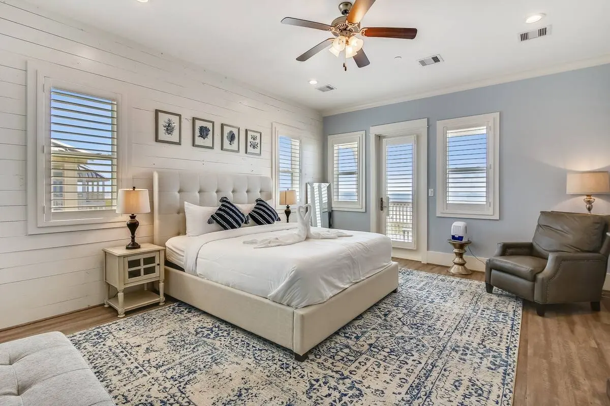Primary bedroom with king bed, shiplap accent wall, and balcony access at Dorado Grande