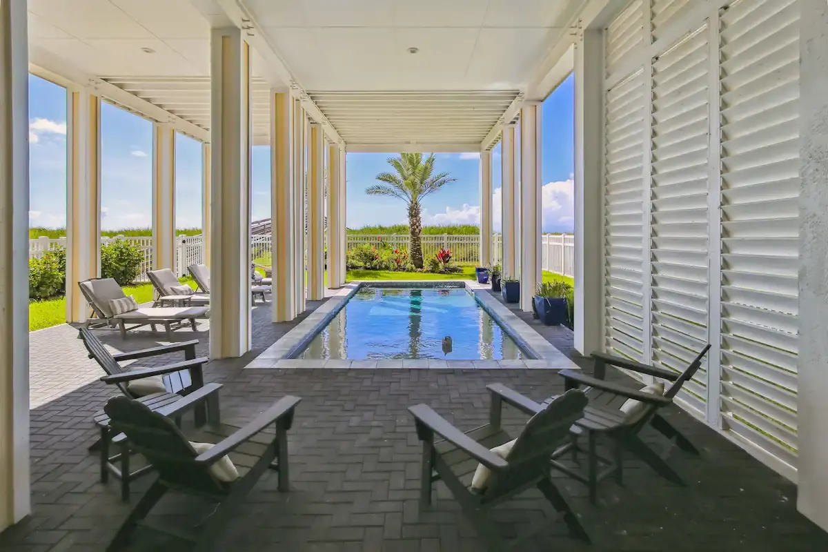 Dorado Grande vacation rental in Galveston — covered private pool with lounge chairs and palm tree
