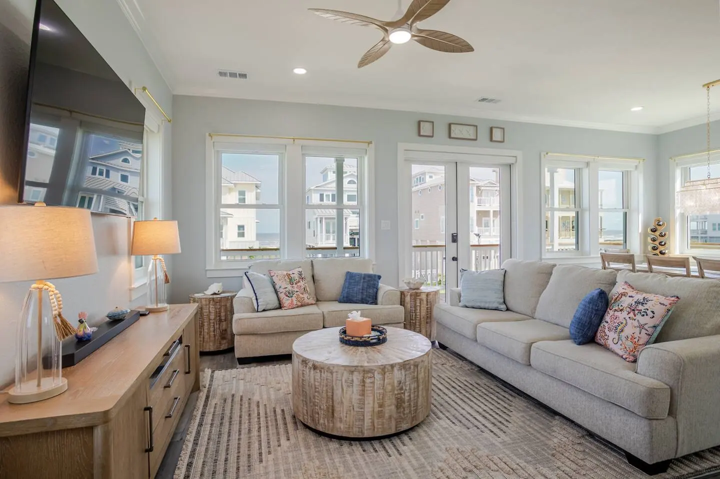 Living room seating area with gulf-view windows and deck access at Alma de Mar