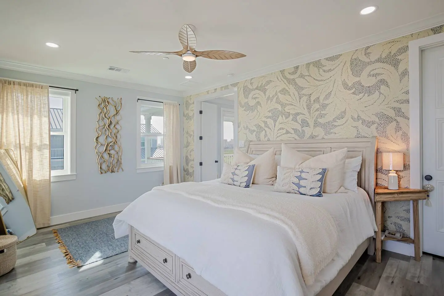 Alma de Mar vacation rental in Galveston — primary bedroom with king bed, patterned accent wall, and coastal ceiling fan