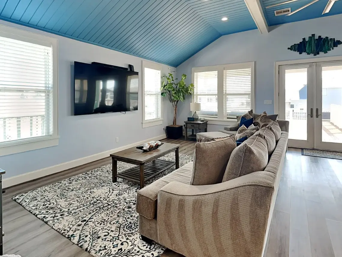 Vaulted great room with French doors, kitchen island, and wine fridge at Tiki Retreat