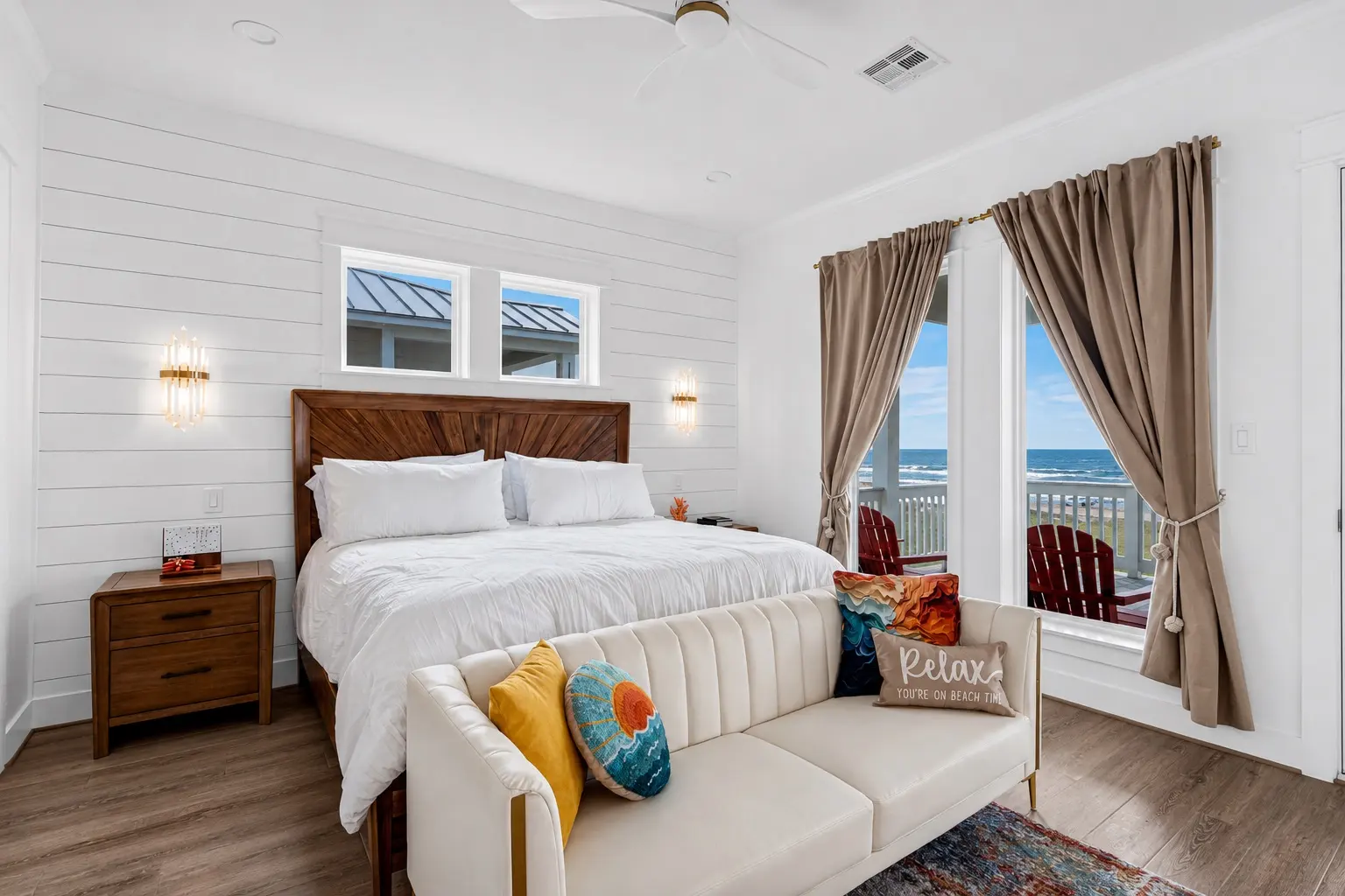 Primary bedroom with shiplap walls and gulf view through balcony doors at Grand Beach Retreat